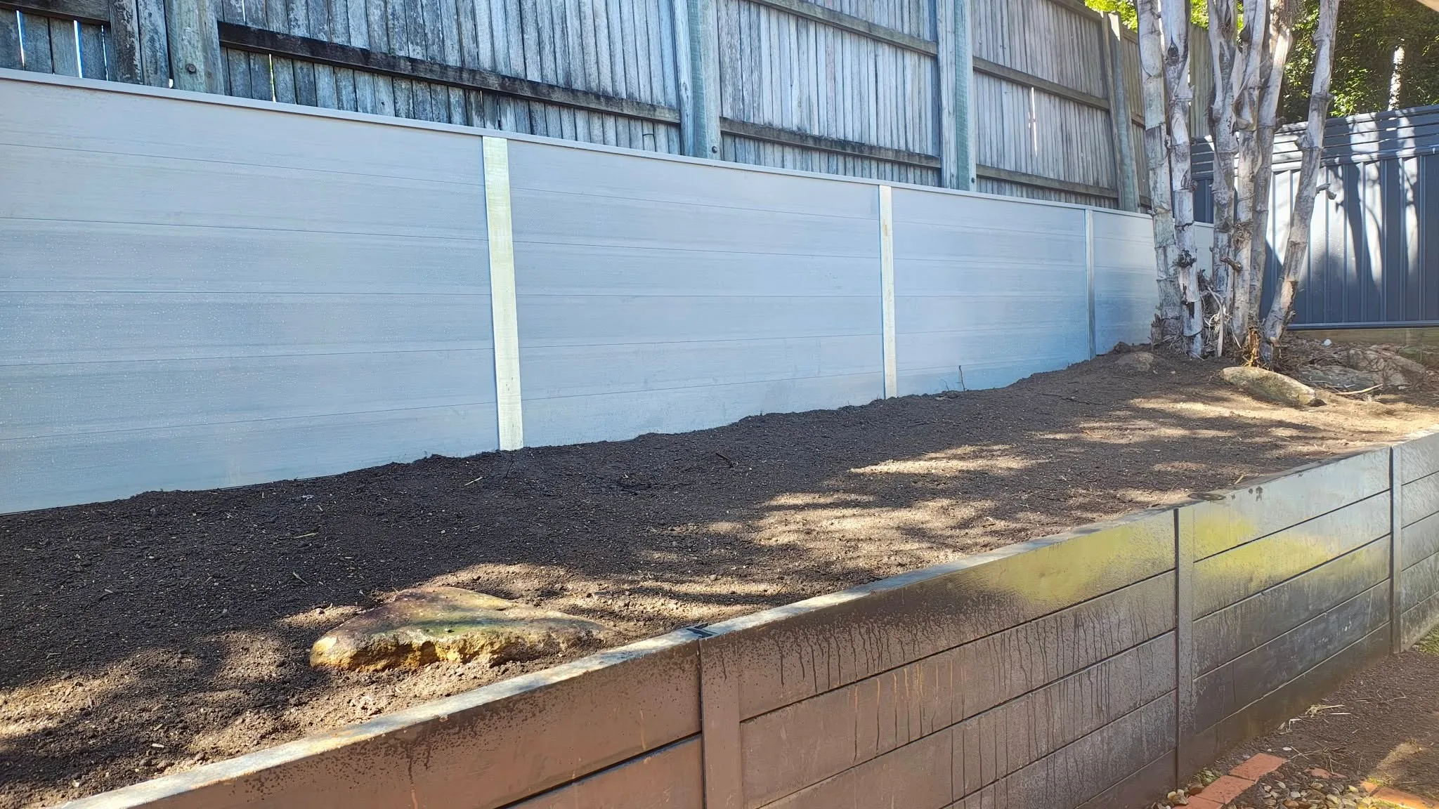 Concrete sleeper retaining wall on a corner block
